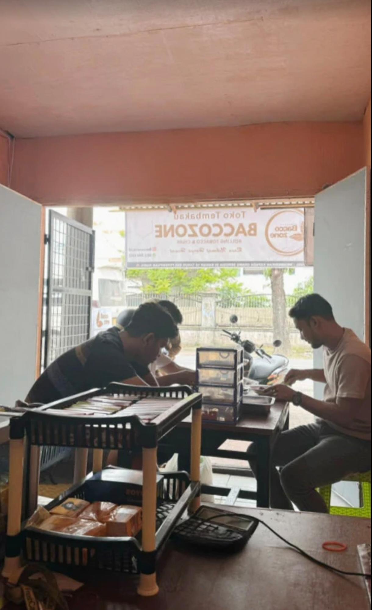 Pelayanan BaccoZone — dua staff melayani dengan profesional